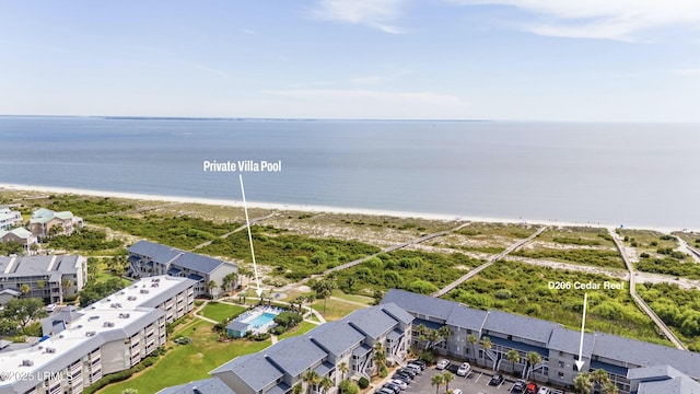 birds eye view of property with a water view and a beach view