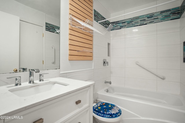 full bathroom with tiled shower / bath, tile walls, vanity, and toilet