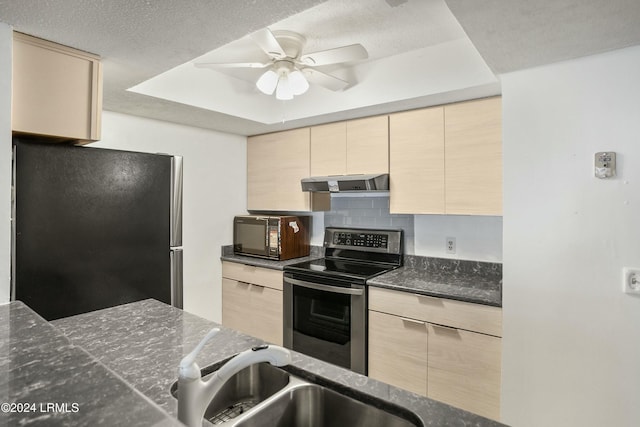 kitchen featuring stainless steel appliances, light brown cabinetry, sink, and decorative backsplash