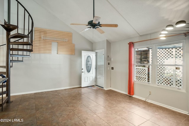 entryway with vaulted ceiling, a textured ceiling, tile patterned floors, and ceiling fan