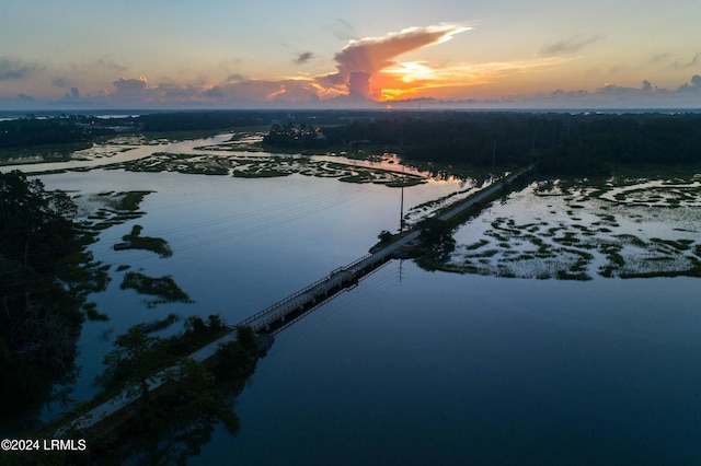 aerial view at dusk featuring a water view