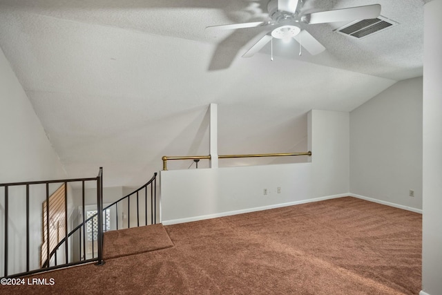 bonus room featuring lofted ceiling, carpet flooring, and a textured ceiling