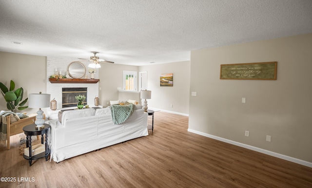 46 Mroz Rd, Beaufort, SC 29906 - living area with wood finished floors, ceiling fan, baseboards, a brick fireplace, and a textured ceiling