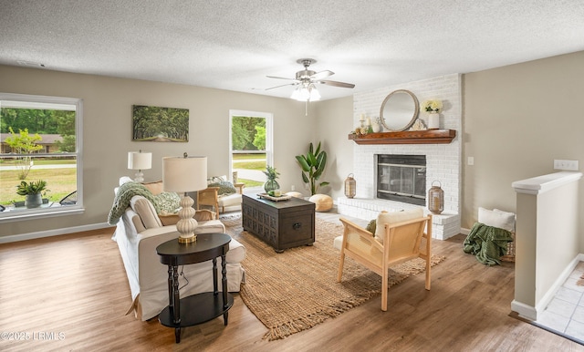 46 Mroz Rd, Beaufort, SC 29906 - living area featuring a ceiling fan, wood finished floors, baseboards, a fireplace, and a textured ceiling