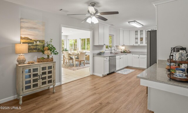 46 Mroz Rd, Beaufort, SC 29906 - kitchen with appliances with stainless steel finishes, a sink, white cabinets, light wood-type flooring, and a ceiling fan