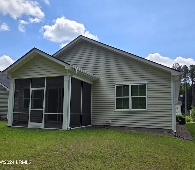 rear view of house with a sunroom and a lawn