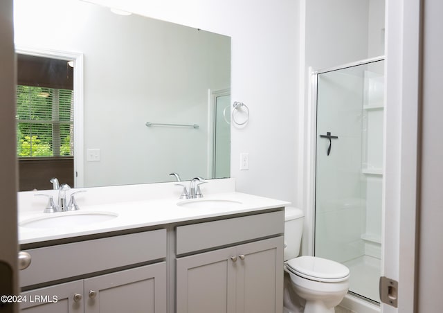 bathroom featuring vanity, an enclosed shower, and toilet