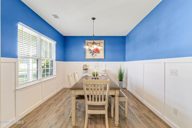 13 Hager Rd, Bluffton, SC 29910 - dining space with a notable chandelier, a wainscoted wall, visible vents, a decorative wall, and wood finished floors