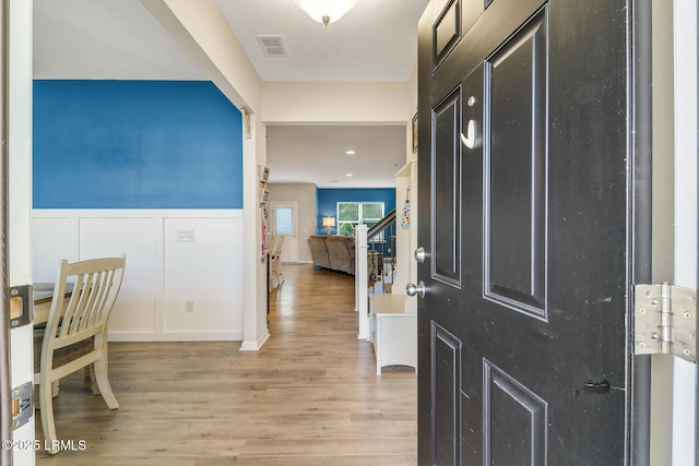 13 Hager Rd, Bluffton, SC 29910 - foyer entrance with light wood-style flooring, a decorative wall, wainscoting, and visible vents