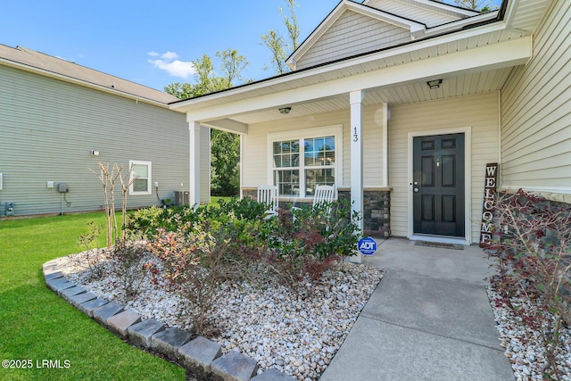 13 Hager Rd, Bluffton, SC 29910 - view of exterior entry featuring stone siding, a lawn, and covered porch