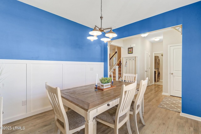 13 Hager Rd, Bluffton, SC 29910 - dining area with an inviting chandelier, stairs, wainscoting, stacked washer / drying machine, and light wood finished floors