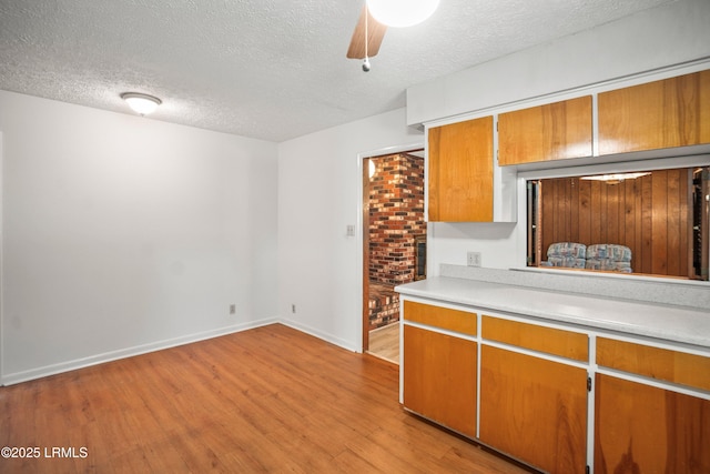 806 Coates Ln, Beaufort, SC 29902 - kitchen with a textured ceiling, light countertops, light wood finished floors, brown cabinets, and baseboards