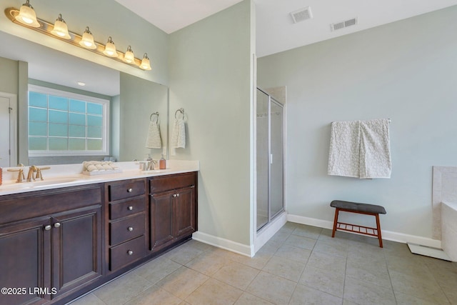 full bathroom with double vanity, visible vents, tile patterned floors, a shower stall, and a sink