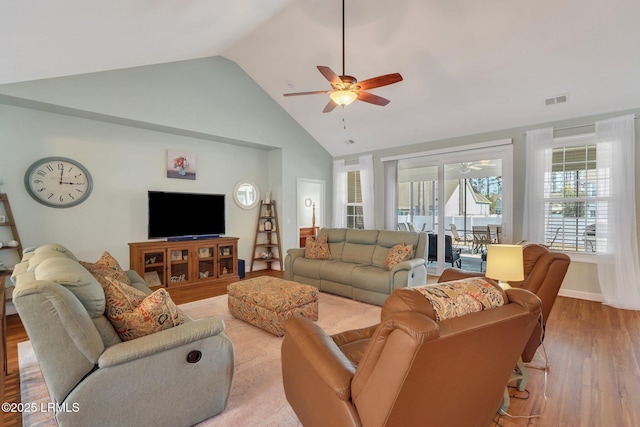 living room with light wood finished floors, baseboards, visible vents, a ceiling fan, and high vaulted ceiling