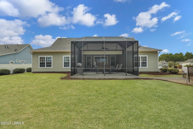 back of property with a lanai, a patio, and a lawn