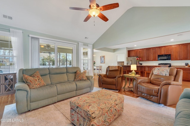 living area with a healthy amount of sunlight, visible vents, and ceiling fan