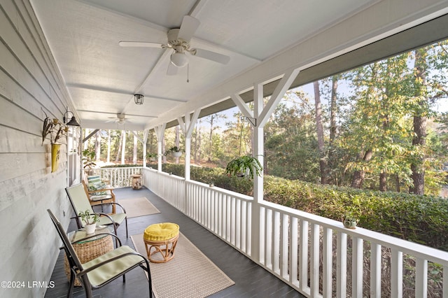 wooden terrace featuring covered porch and ceiling fan