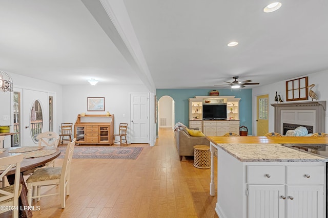 kitchen featuring white cabinetry, light stone countertops, ceiling fan, and light hardwood / wood-style flooring