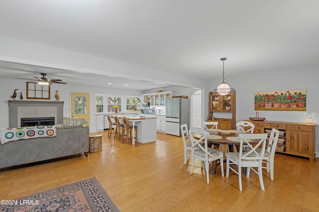 dining space with ceiling fan and light wood-type flooring