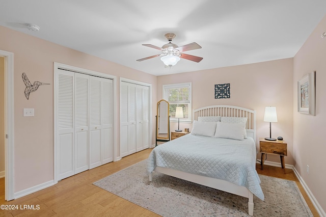 bedroom with multiple closets, ceiling fan, and light wood-type flooring