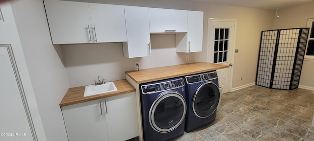 washroom featuring independent washer and dryer, sink, and cabinets