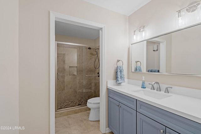 bathroom featuring a shower with door, vanity, tile patterned flooring, and toilet