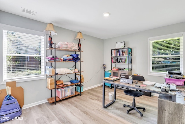 office with a healthy amount of sunlight and light hardwood / wood-style floors