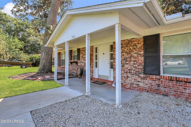 property entrance featuring a porch and a lawn