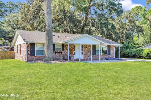 ranch-style home with covered porch and a front yard