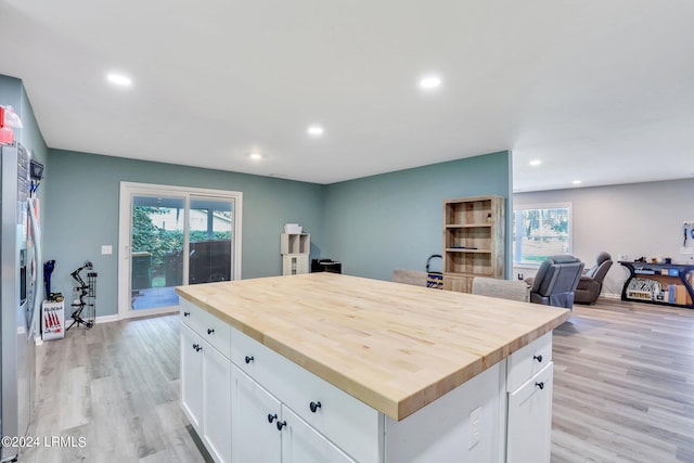 kitchen with a healthy amount of sunlight, a center island, and white cabinets