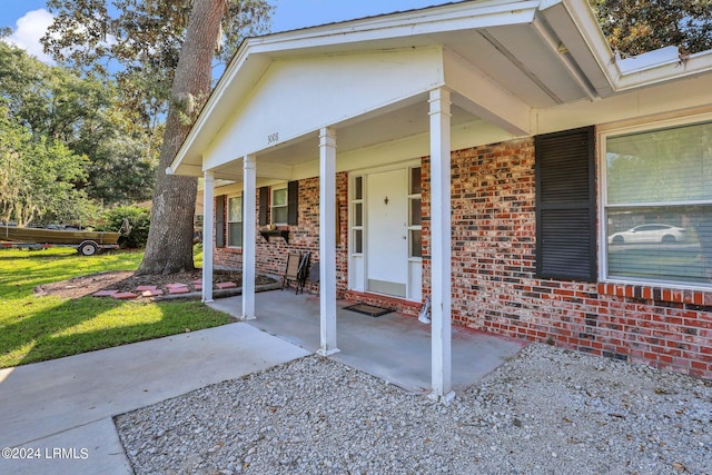 view of exterior entry with a porch