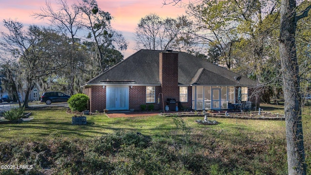 1101 Beavers Den, Beaufort, SC 29902 - view of front facade featuring a chimney, brick siding, a sunroom, and a front lawn