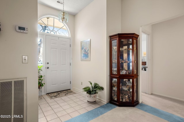 1101 Beavers Den, Beaufort, SC 29902 - entryway featuring light tile patterned flooring, a notable chandelier, light carpet, a high ceiling, and visible vents