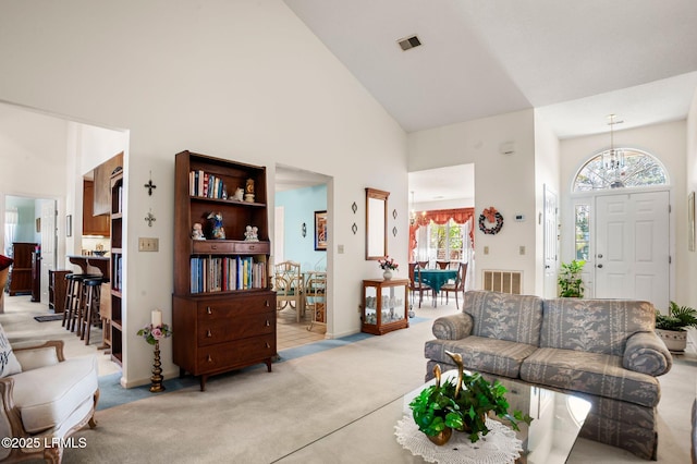 1101 Beavers Den, Beaufort, SC 29902 - carpeted living room featuring visible vents, a towering ceiling, and a chandelier