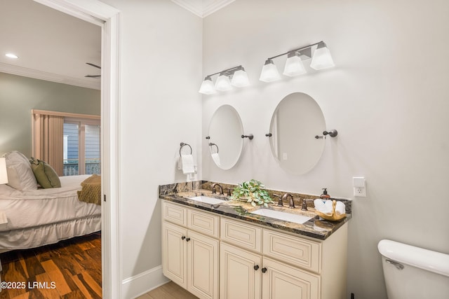 bathroom featuring vanity, hardwood / wood-style floors, ornamental molding, and toilet