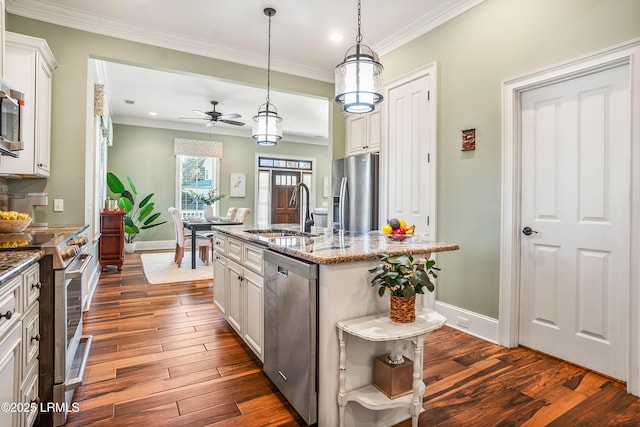 kitchen featuring sink, appliances with stainless steel finishes, a kitchen island with sink, white cabinetry, and hanging light fixtures