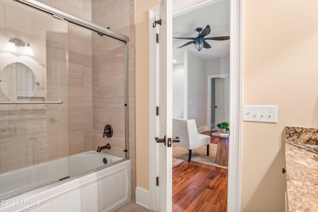 bathroom with vanity, wood-type flooring, enclosed tub / shower combo, and ceiling fan