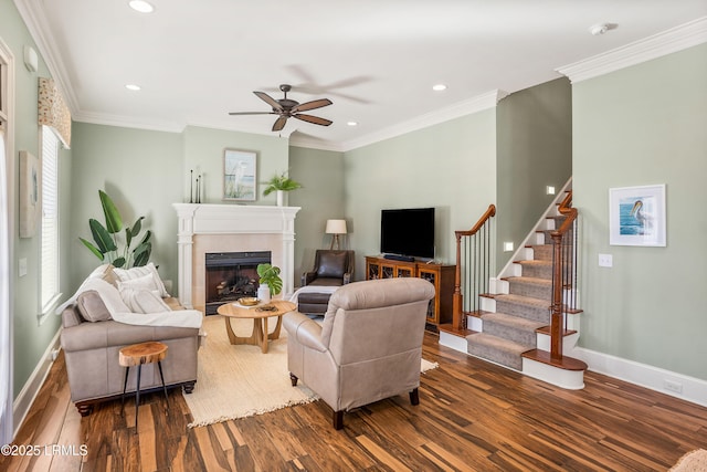 living room with crown molding, plenty of natural light, dark hardwood / wood-style flooring, and a tiled fireplace