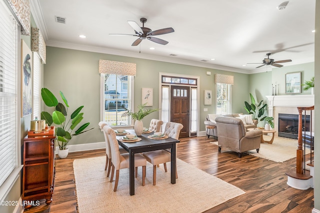 dining area featuring crown molding, dark wood-type flooring, and ceiling fan