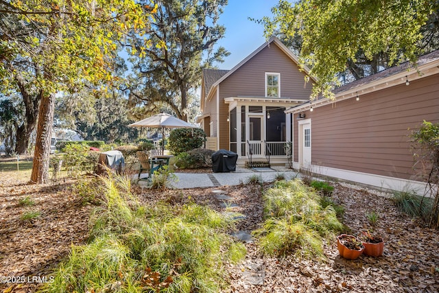 rear view of property featuring a patio and a sunroom