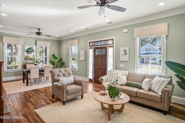 living room featuring hardwood / wood-style flooring, ornamental molding, and ceiling fan