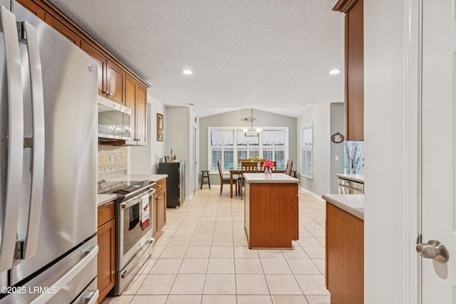 69 Wheatfield Cir, Bluffton, SC 29910 - kitchen with appliances with stainless steel finishes, backsplash, brown cabinets, a kitchen island, and light countertops