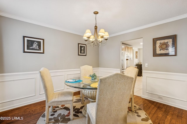 69 Wheatfield Cir, Bluffton, SC 29910 - dining room featuring a chandelier, ornamental molding, wood finished floors, a decorative wall, and a wainscoted wall