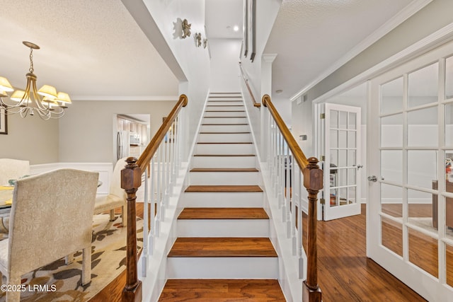 69 Wheatfield Cir, Bluffton, SC 29910 - stairs with crown molding, wood finished floors, a chandelier, a textured ceiling, and french doors