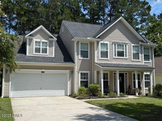 69 Wheatfield Cir, Bluffton, SC 29910 - view of front facade with driveway, a front lawn, a shingled roof, and a porch