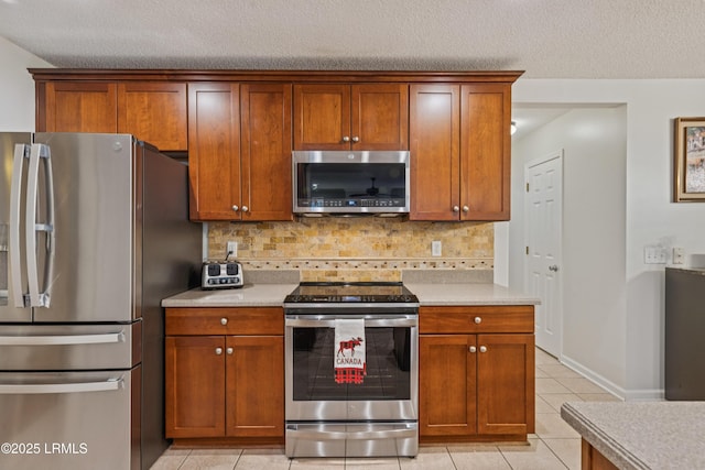 69 Wheatfield Cir, Bluffton, SC 29910 - kitchen featuring stainless steel appliances, light tile patterned floors, light countertops, backsplash, and brown cabinets