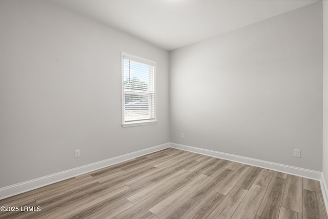 unfurnished room featuring baseboards and light wood-style flooring