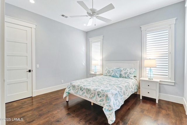 bedroom featuring ceiling fan, visible vents, baseboards, and wood finished floors