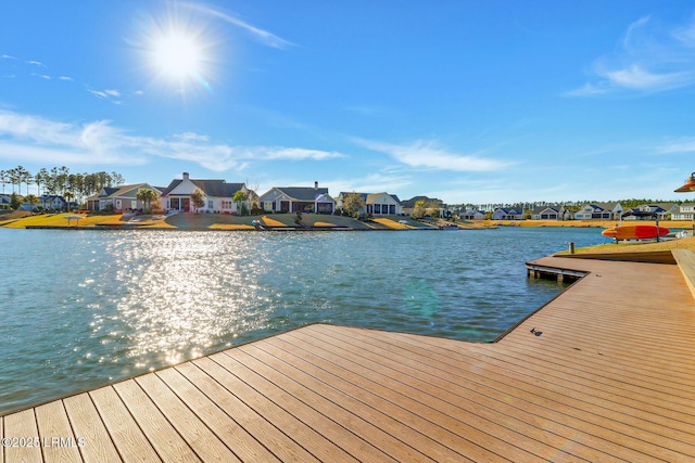 view of dock with a residential view and a water view