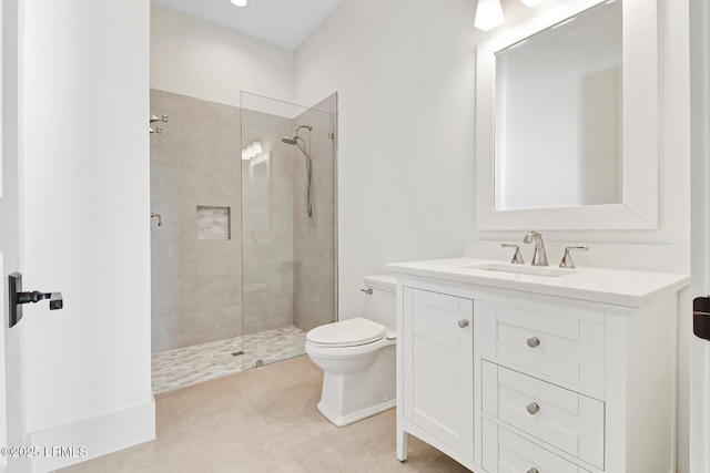 bathroom featuring a tile shower, tile patterned flooring, toilet, and vanity